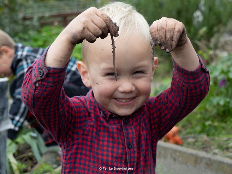 Kind tijdens oogstfeest Buitenlokaal Klimboom