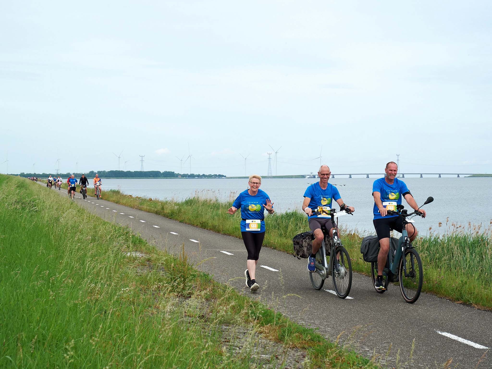 Fietsers en loper op de dijk