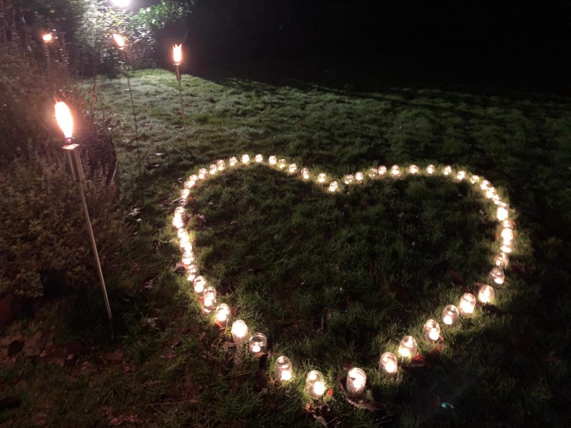 Een hart van brandende kaarsjes tijdens wereldlichtjesdag