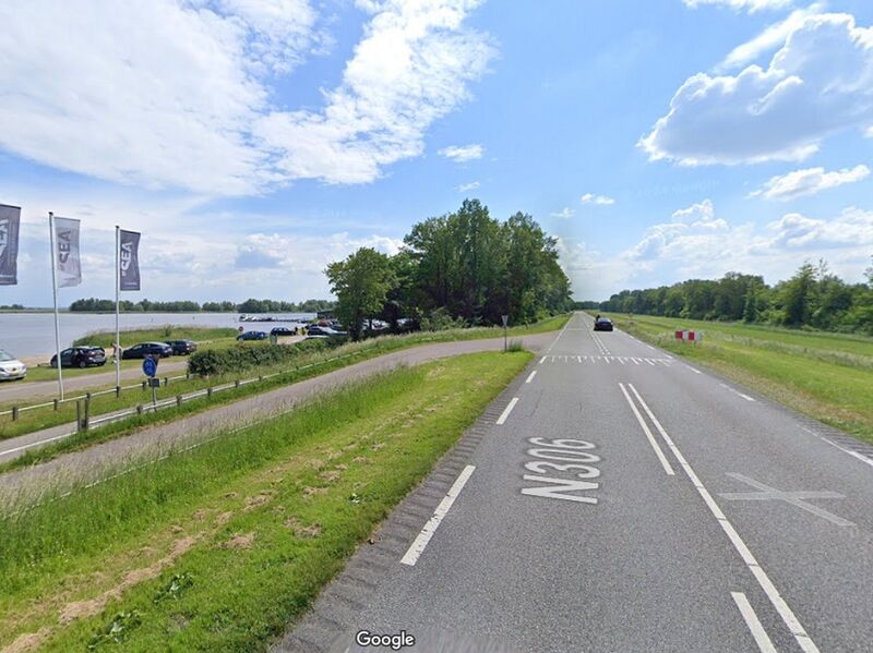 Een foto van de weg die toegang biedt tot het Spijkstrand, met Beachclub NU. 